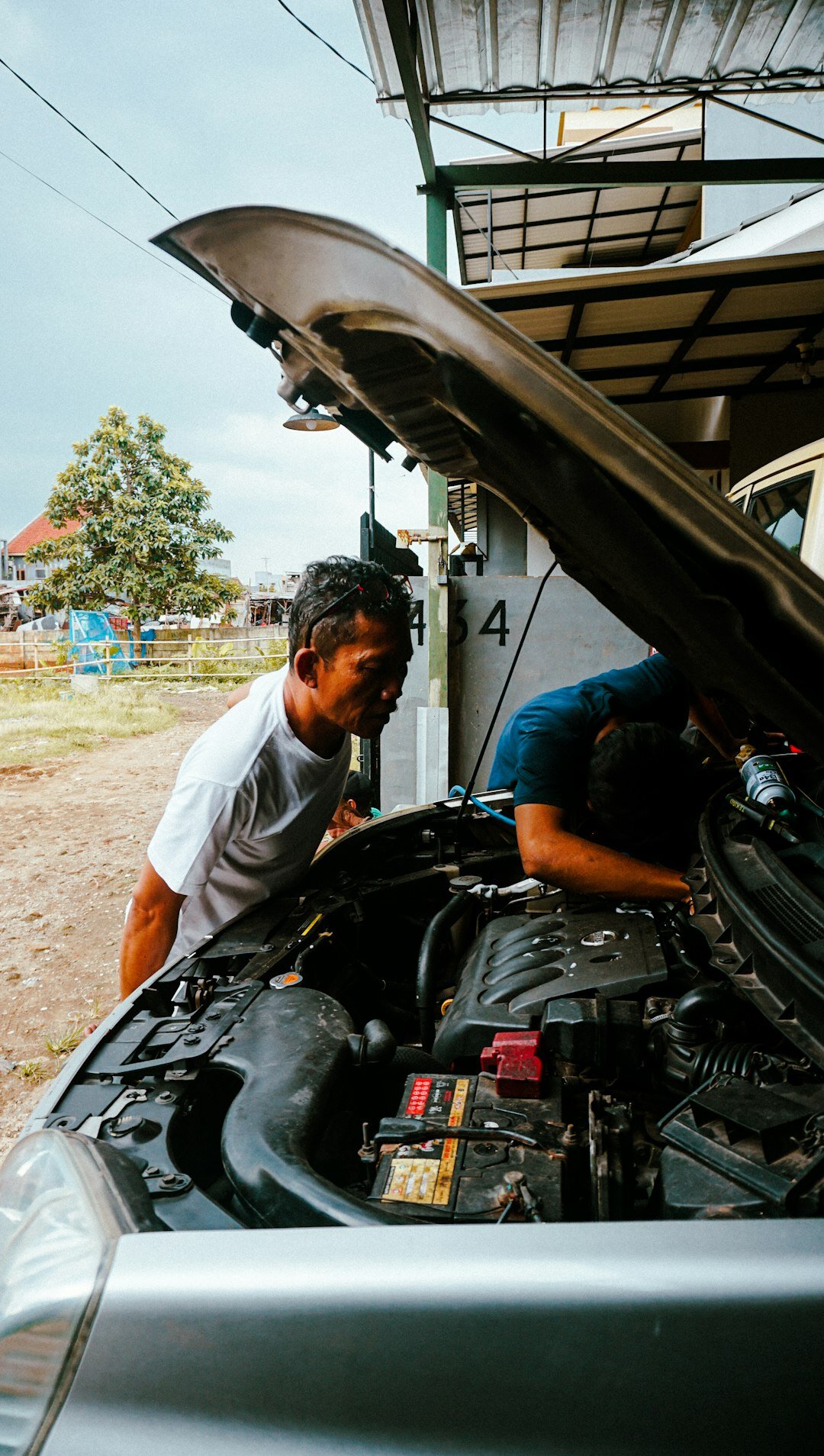 person inspecting car engine
